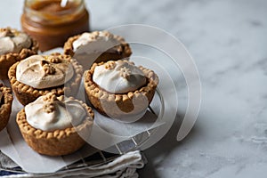 Lemon curd tartlets with whipped meringue on a wire rack. Copy space and close up