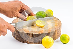 Lemon cut half by hand on round shopping board white background