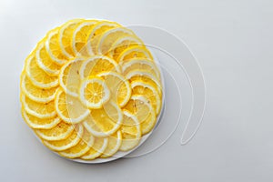 Lemon cut into slices on a white plate. Juicy round pieces of yellow lemon. Citrus is a source of vitamin and ascorbic acid