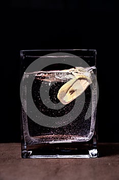 lemon in a cut in water in a glass on a black background