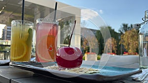 lemon drink and orange drink on the summer terrace near a delicious mousse dessert in the form of a large petiole on