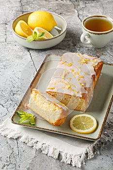Lemon Drizzle Cake has a crunchy sugar glaze that crystallizes on top closeup on the plate. Vertical photo