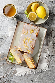 Lemon Drizzle Cake has a crunchy sugar glaze that crystallizes on top closeup on the plate. Vertical top view