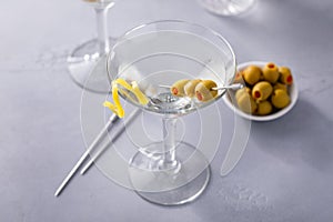 Lemon drop martini cocktail with olives and a lemon twist