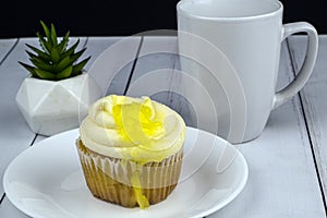 Lemon filled cup cake with a cup of coffee