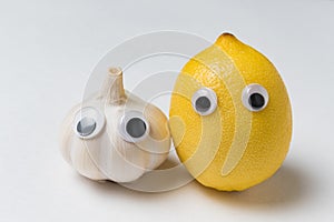 Lemon and garlic with Googly eyes and funny faces. Health foods concept