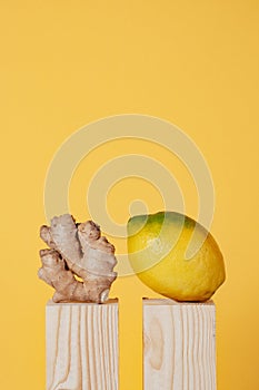 lemon and ginger on wooden pedestal on yellow background