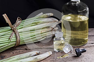 Lemon Grass Cymbopogon citratus and Citronella oil in glass bottle and glass dropper on wood table background. Lemongrass oil