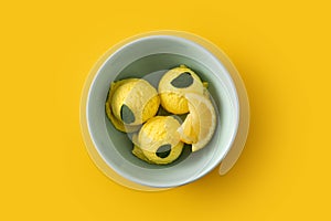 Lemon ice cream scoop decorated with mint leaves in bowl