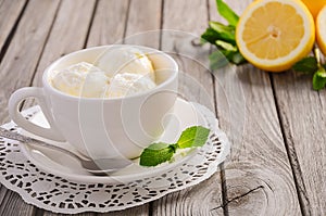 Lemon ice cream in white cup on rustic wooden background