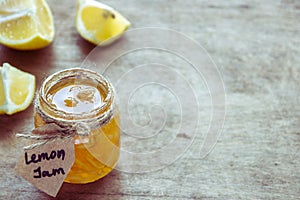 Lemon jam in jar and lemon`s slices on a table