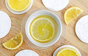 Lemon juice, lemon slices and cotton pads. Ingredients for preparing homemade hair mask or face toner. Natural beauty treatment