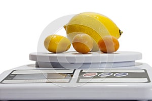 Lemon and kumquats on a kitchen digital scale