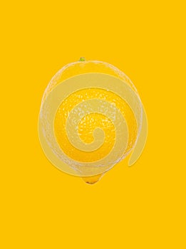 Lemon levitate in air on yellow background. Concept of fruit levitation