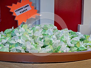 Lemon lime flavored taffy piled in a barrel with sign in store