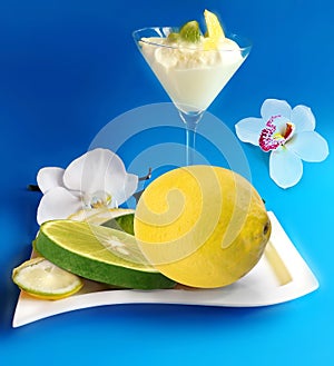 Lemon lime grape orange icecream orchids flowers but on blue  white yellow background fruite leaves  berry  copy space tem