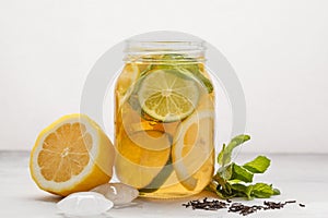 Lemon lime ice tea with mint in a glass jar, white background, c