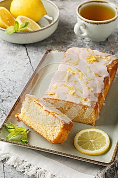 Lemon loaf cake, classic recipe, decorated with sugar icing closeup on the plate. Vertical