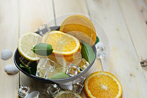 Lemon Orange Leaves Cube Ice Sea Shells Citrus in a Black Bowl