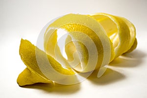 Lemon peel or lemon twist on white background. Close-up.