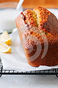 Lemon poppy seed pound cake on a wire rack. White stone background.