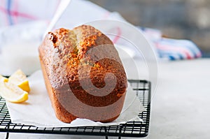 Lemon poppy seed pound cake on a wire rack. White stone background.