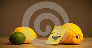 Lemon with post-it note laughing on citrus fruits