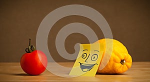 Lemon with post-it note smiling at tomato
