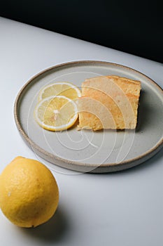 Lemon pound cake with slices of lemon sugar icing on black and white background.