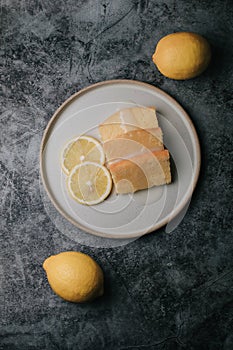 Lemon pound cake with slices of lemon sugar icing on black and white background.