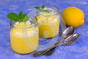 Lemon pudding or Kurd decorated with mint on a light blue background. Copy space. photo