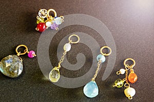 Lemon quartz, ruby, pearl,labradorite,apatite, green chalcedony, blue topaz necklace charm isolated on black background.