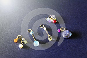 Lemon quartz, ruby, pearl, labradorite, apatite, green chalcedony, blue topaz necklace charm isolated on black background.