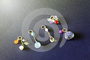 Lemon quartz, ruby, pearl,labradorite,apatite, green chalcedony, blue topaz necklace charm isolated on black background.