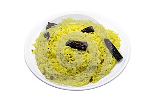 Lemon rice with red chillies, served on a white plate, selected focus
