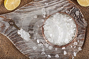 Lemon salt or Citric acid on wood background. Citric acid or lemon salt in wooden bowl. Lemon salt for cooking on wooden