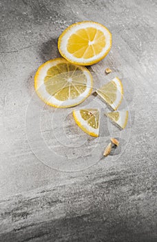 Lemon slice on gray table. Fresh citrous fruits piece, isolated with copyspace photo