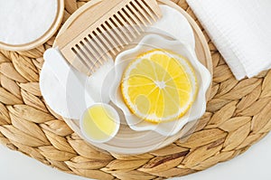 Lemon slice, lemon juice and wooden hairbrush. Ingredients for preparing homemade hair toner or beauty mask.