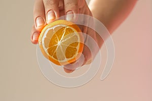 Lemon slice mock up in the hand of a young woman on a beige background with a beautiful shadow. Minimalism