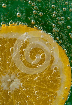 Lemon slice in water with bubbles