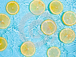 Lemon slices in clean transparent water, blue bg