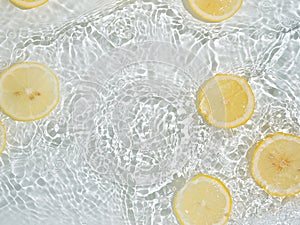 Lemon slices in clean transparent water, white bg