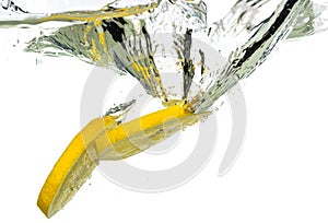 Lemon slices and lime falling into water and splash on white background