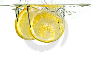 Lemon slices and lime falling into water and splash on white background