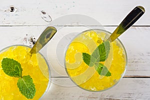 Lemon slushie in glass on white wood