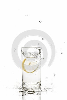 Lemon splashes in water glass isolated on white background