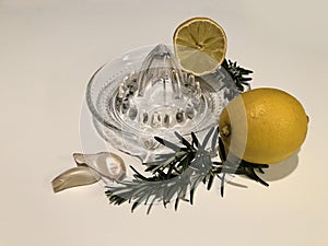 Lemon squeezer, lemons, rosemary and garlic