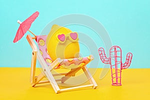 Lemon in sunglasses in the sunbed with umbrela at the beach