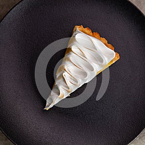 Lemon tart with protein cream on black plate
