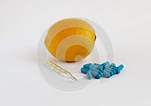 Lemon, thermometer and medicine pills on a white background.Medicine technology and healthcare concept.
